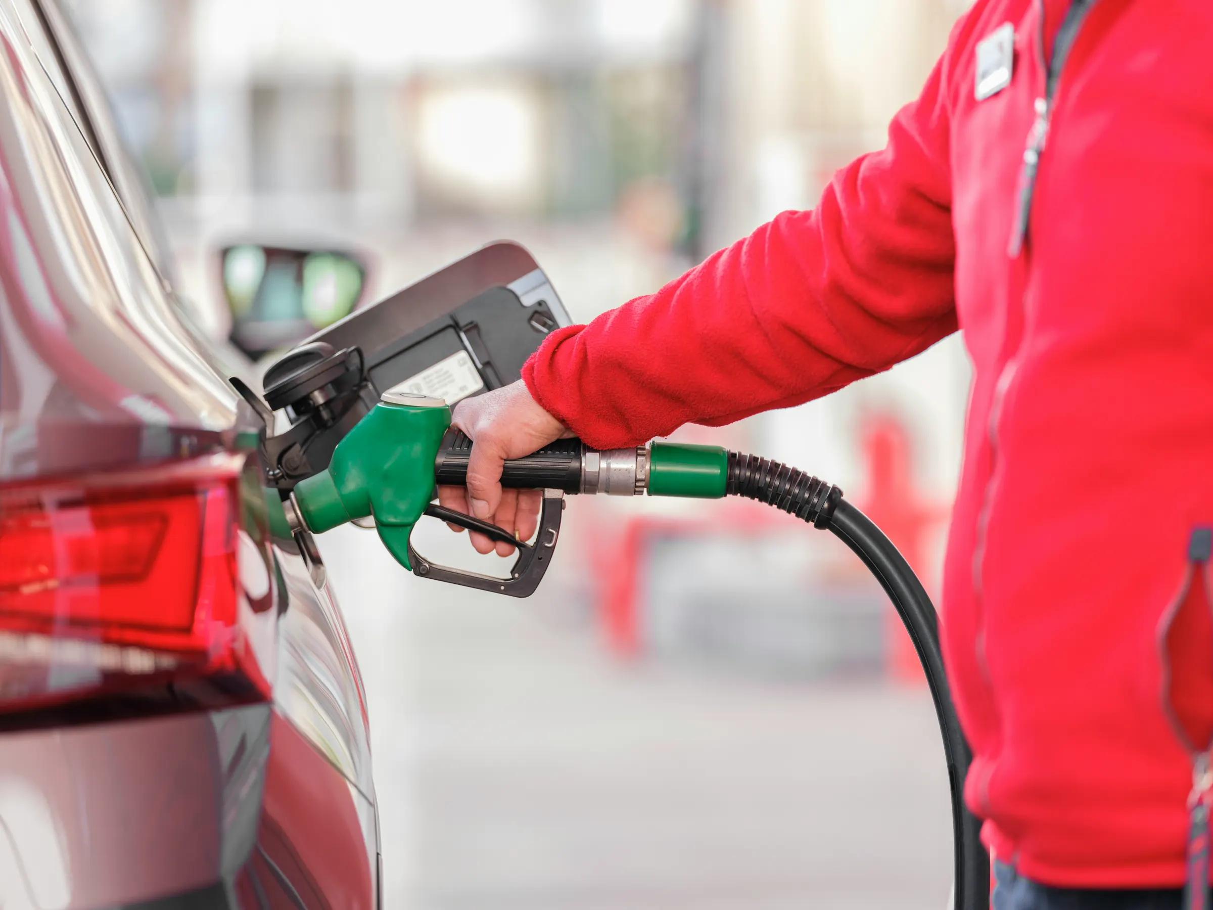 A driver refuelling a car at a filling station forecourt.